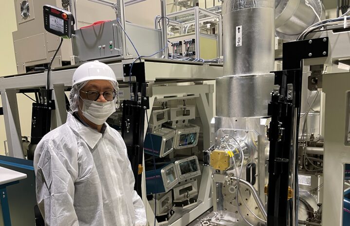 世界最高出力200J×10Hzでレーザーシステムが動作したレーザー増幅器の横に立つ川嶋氏