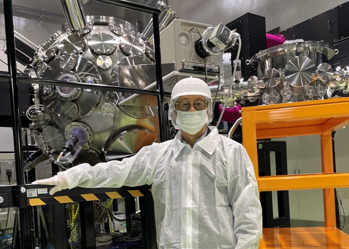 写真１：レーザーフュージョン評価用光照射システムの前に立つ川嶋氏